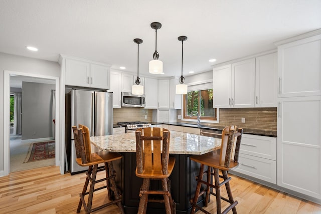 3440 Glenarden Rd, Arden Hills, MN 55112 - kitchen with stainless steel appliances, white cabinets, a breakfast bar area, tasteful backsplash, and recessed lighting