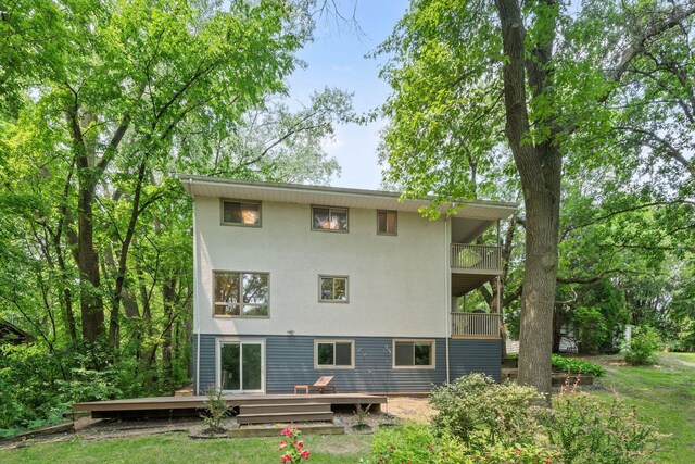 3440 Glenarden Rd, Arden Hills, MN 55112 - back of house with a balcony, a deck, stucco siding, and a lawn