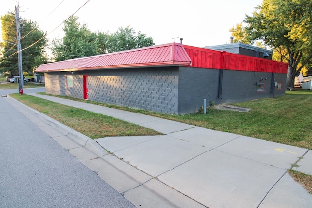 641 Forest Ave, Albany, MN 56307 - view of side of home featuring concrete block siding, a lawn, and a metal roof