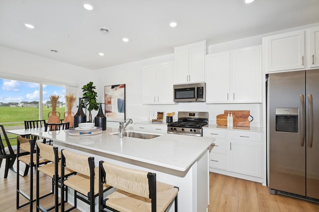 2134 Tyrone Dr, Shakopee, MN 55379 - kitchen with stainless steel appliances, a sink, light countertops, a kitchen island with sink, and white cabinetry