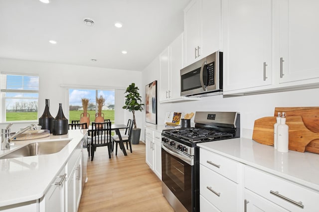 2134 Tyrone Dr, Shakopee, MN 55379 - kitchen with appliances with stainless steel finishes, a sink, recessed lighting, white cabinetry, and light wood finished floors