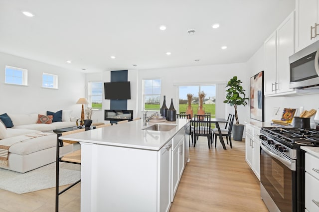 2134 Tyrone Dr, Shakopee, MN 55379 - kitchen with appliances with stainless steel finishes, a sink, open floor plan, a kitchen bar, and recessed lighting