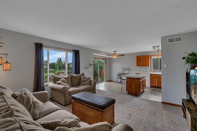 1285 Stone Ridge Rd, Sauk Rapids, MN 56379 - living area featuring ceiling fan, a textured ceiling, and baseboards