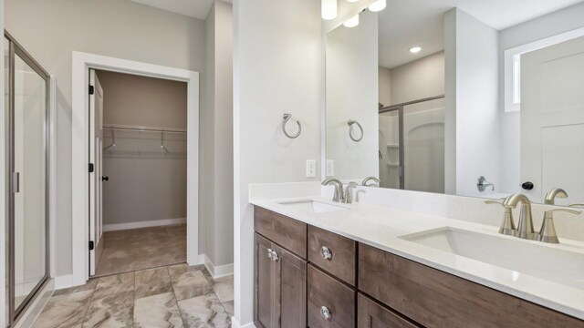 5574 130th Way N, Hugo, MN 55038 - bathroom with a shower stall, a spacious closet, marble look tile flooring, double vanity, and baseboards
