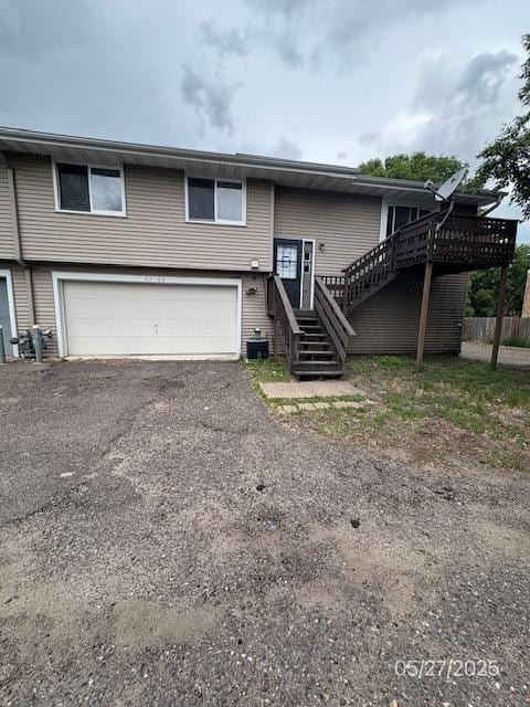 6769 Humboldt Ave N, Brooklyn Center, MN 55430 - view of front of home featuring a garage, stairway, central AC unit, and asphalt driveway