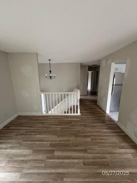 6769 Humboldt Ave N, Brooklyn Center, MN 55430 - empty room featuring wood finished floors, a chandelier, baseboards, and a textured ceiling