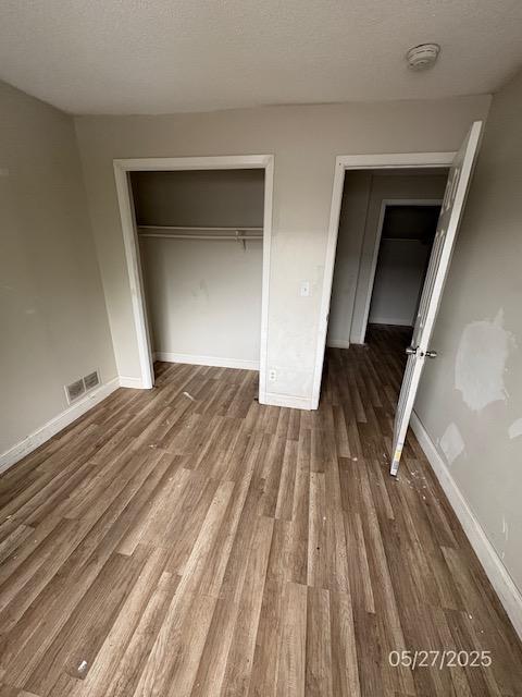 6769 Humboldt Ave N, Brooklyn Center, MN 55430 - unfurnished bedroom with wood finished floors, a closet, and baseboards