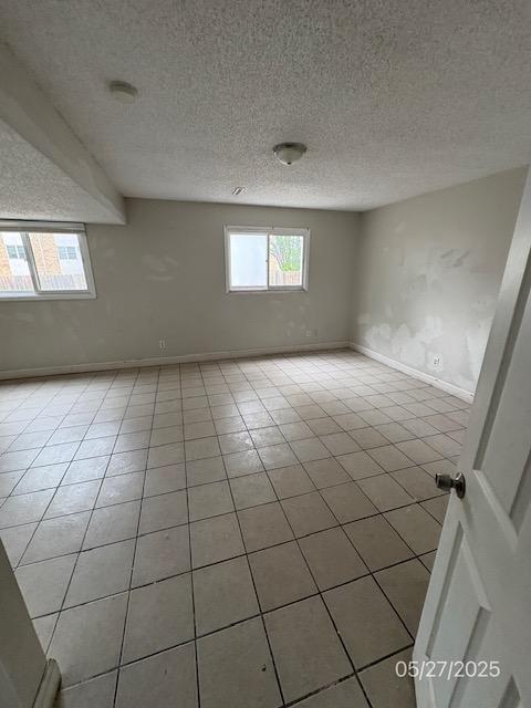 6769 Humboldt Ave N, Brooklyn Center, MN 55430 - unfurnished room featuring baseboards, a textured ceiling, and light tile patterned flooring