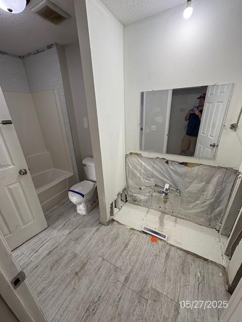 6769 Humboldt Ave N, Brooklyn Center, MN 55430 - full bath featuring wood finished floors, a textured ceiling, and toilet