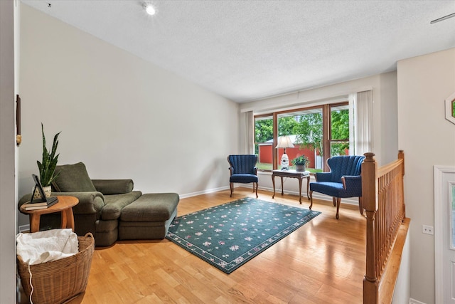 8165 240th St W, Eureka Twp, MN 55044 - living area with light wood-type flooring, a textured ceiling, and baseboards
