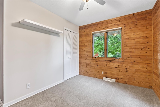 8165 240th St W, Eureka Twp, MN 55044 - unfurnished bedroom with wooden walls, carpet, a closet, baseboards, and a ceiling fan