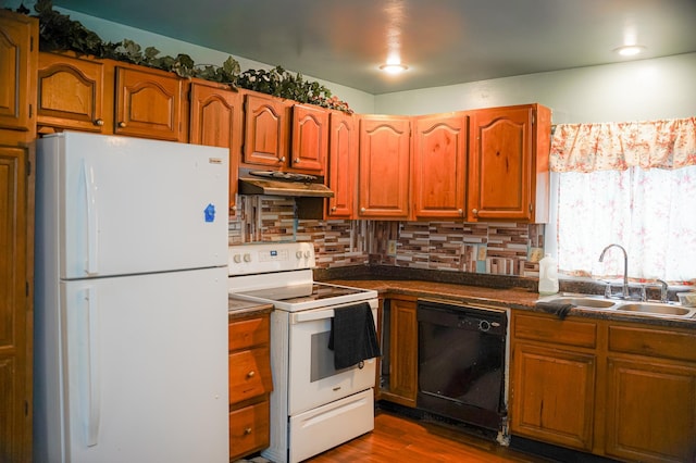 89 Winnipeg Ave, Saint Paul, MN 55117 - kitchen with white appliances, a sink, under cabinet range hood, dark countertops, and backsplash