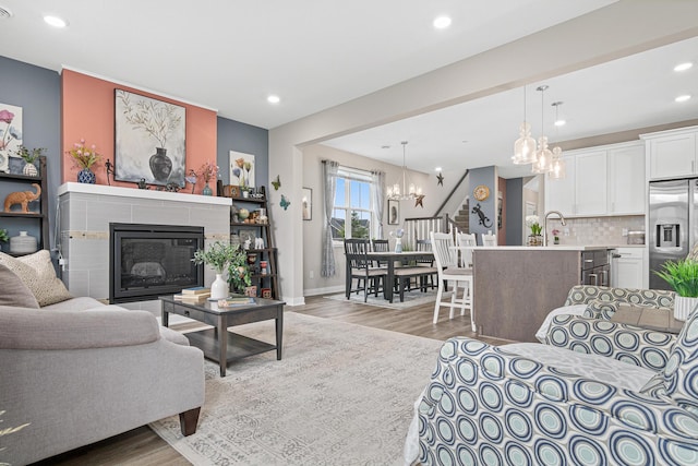 18165 Garland Path, Lakeville, MN 55044 - living area with a chandelier, light wood-style flooring, recessed lighting, and a tiled fireplace