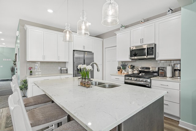 18165 Garland Path, Lakeville, MN 55044 - kitchen featuring appliances with stainless steel finishes, an island with sink, decorative backsplash, dark wood-style flooring, and recessed lighting
