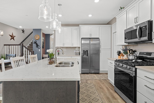18165 Garland Path, Lakeville, MN 55044 - kitchen with stainless steel appliances, light wood-style flooring, white cabinets, backsplash, and recessed lighting