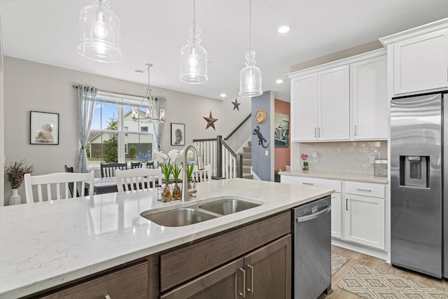 18165 Garland Path, Lakeville, MN 55044 - kitchen featuring appliances with stainless steel finishes, white cabinets, backsplash, light wood-style floors, and pendant lighting
