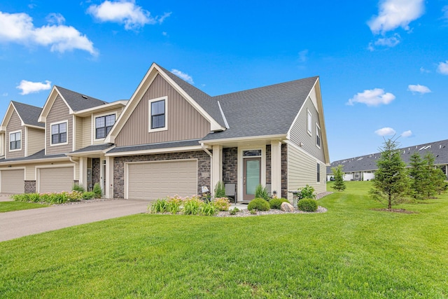 18165 Garland Path, Lakeville, MN 55044 - view of front of property featuring a garage, asphalt driveway, a front yard, board and batten siding, and stone siding