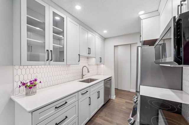 4584 Cedar Lake Rd S Unit 1, Saint Louis Park, MN 55416 - kitchen featuring stainless steel appliances, white cabinets, backsplash, glass insert cabinets, and recessed lighting