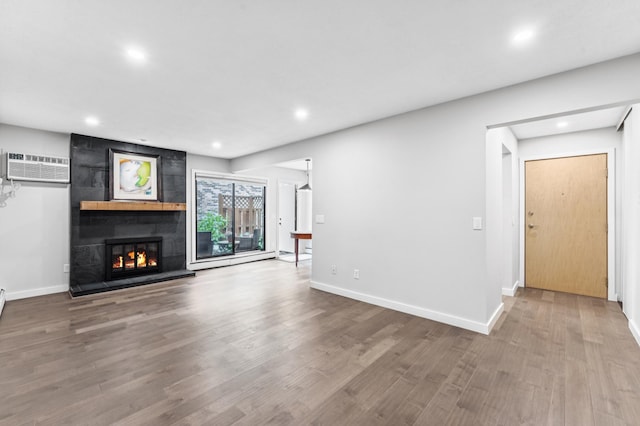 4584 Cedar Lake Rd S Unit 1, Saint Louis Park, MN 55416 - unfurnished living room featuring a wall mounted AC, recessed lighting, wood finished floors, and a large fireplace
