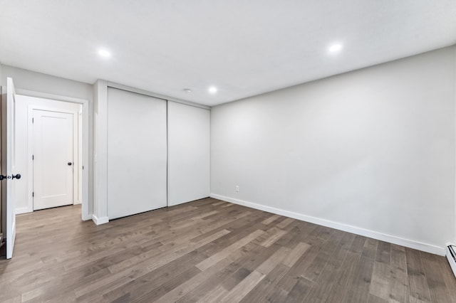 4584 Cedar Lake Rd S Unit 1, Saint Louis Park, MN 55416 - unfurnished bedroom featuring wood finished floors, recessed lighting, a closet, and a baseboard heating unit