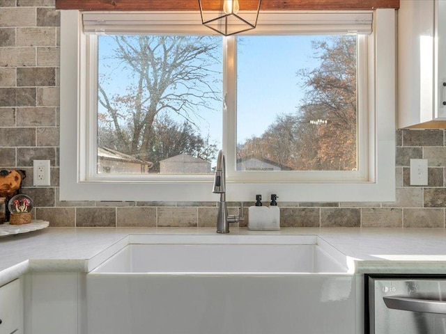 5335 Pine Beach Rd, Brainerd, MN 56401 - kitchen view of a sink, dishwasher, white cabinetry, light countertops, and decorative backsplash