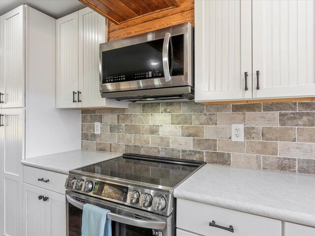 5335 Pine Beach Rd, Brainerd, MN 56401 - kitchen with stainless steel appliances, white cabinetry, and backsplash