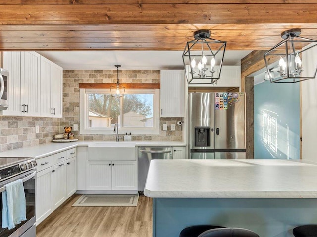 5335 Pine Beach Rd, Brainerd, MN 56401 - kitchen with appliances with stainless steel finishes, a chandelier, a sink, and white cabinets