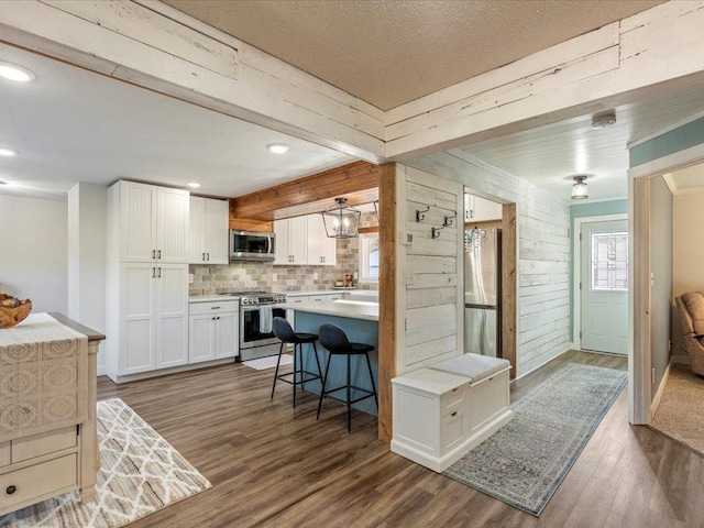 5335 Pine Beach Rd, Brainerd, MN 56401 - kitchen featuring stainless steel appliances, dark wood finished floors, white cabinets, light countertops, and a breakfast bar