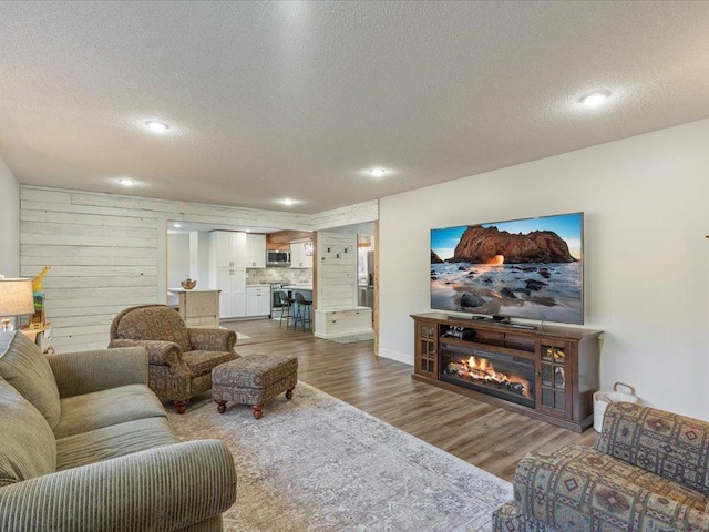 5335 Pine Beach Rd, Brainerd, MN 56401 - living area with a textured ceiling, wood finished floors, a glass covered fireplace, and recessed lighting