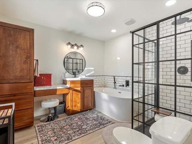 5335 Pine Beach Rd, Brainerd, MN 56401 - full bathroom featuring a freestanding bath, toilet, wood finished floors, vanity, and tiled shower