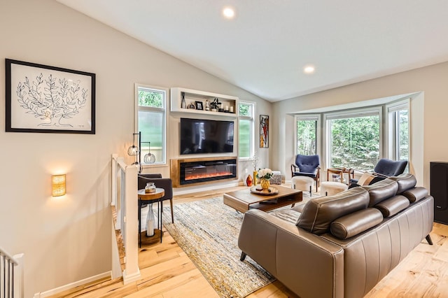 5691 Birch Trl, Shoreview, MN 55126 - living room featuring vaulted ceiling, wood finished floors, a glass covered fireplace, and recessed lighting