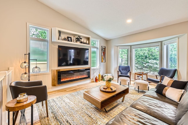 5691 Birch Trl, Shoreview, MN 55126 - living area featuring vaulted ceiling, wood finished floors, healthy amount of natural light, and a glass covered fireplace
