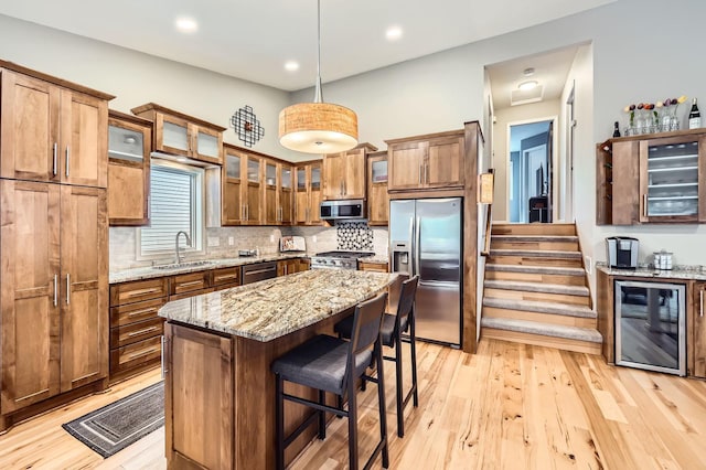 5691 Birch Trl, Shoreview, MN 55126 - kitchen featuring beverage cooler, appliances with stainless steel finishes, a sink, a kitchen breakfast bar, and light wood finished floors