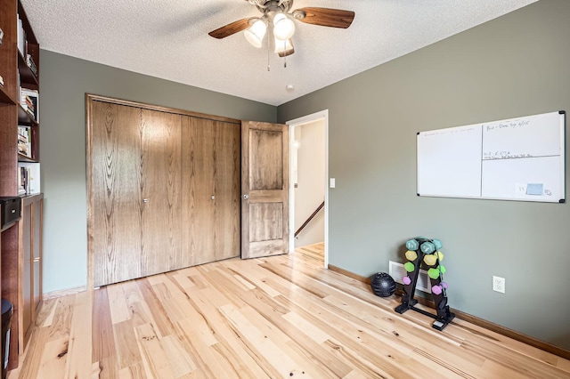 5691 Birch Trl, Shoreview, MN 55126 - unfurnished bedroom with wood finished floors, baseboards, a textured ceiling, a closet, and a ceiling fan