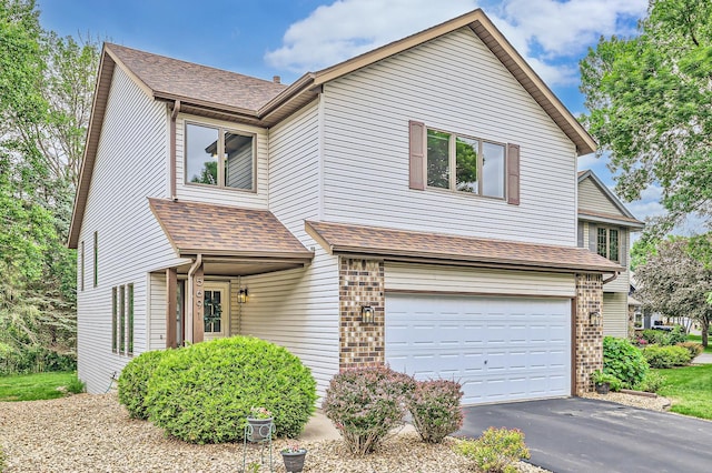 5691 Birch Trl, Shoreview, MN 55126 - traditional home featuring an attached garage, driveway, and a shingled roof