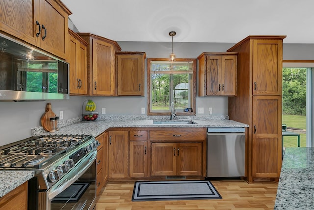 823 Morningside Loop, Saint Joseph, MN 56374 - kitchen featuring stainless steel appliances, brown cabinetry, light wood-style floors, and light stone countertops
