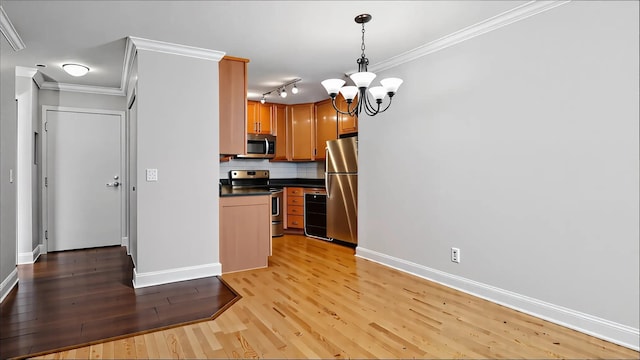 3540 Hennepin Ave Unit 309, Minneapolis, MN 55408 - kitchen with stainless steel appliances, dark countertops, baseboards, light wood finished floors, and a chandelier