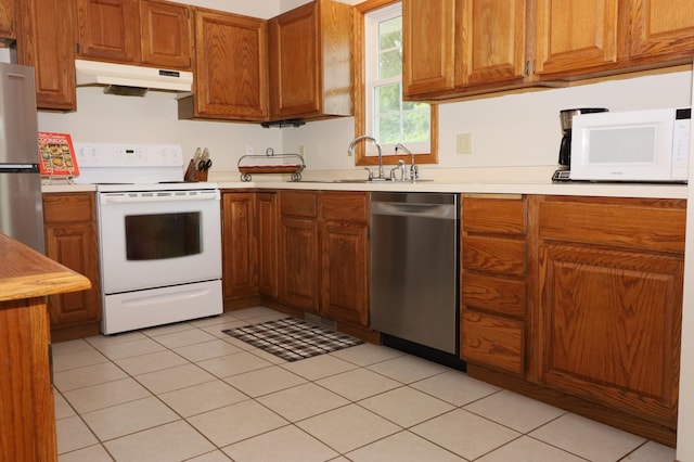 7971 Upper 145th St W, Apple Valley, MN 55124 - kitchen featuring appliances with stainless steel finishes, under cabinet range hood, brown cabinetry, and light countertops