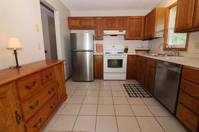 7971 Upper 145th St W, Apple Valley, MN 55124 - kitchen featuring stainless steel appliances, under cabinet range hood, brown cabinets, light countertops, and light tile patterned floors