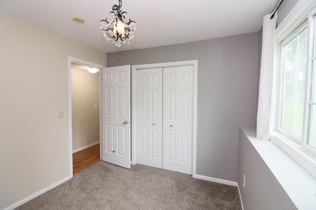 7971 Upper 145th St W, Apple Valley, MN 55124 - unfurnished bedroom featuring light carpet, a closet, and a chandelier