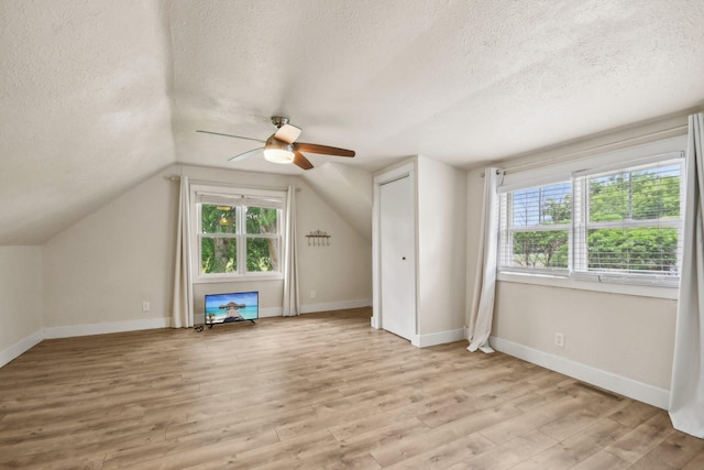 2256 40th Ave Unit X, East Farmington, WI 54020 - bonus room featuring a textured ceiling, ceiling fan, light wood-style flooring, baseboards, and lofted ceiling