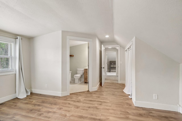 2256 40th Ave Unit X, East Farmington, WI 54020 - bonus room with a textured ceiling, lofted ceiling, light wood finished floors, and baseboards