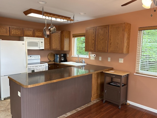 32813 Whispering Springs Loop, Erhard, MN 56534 - kitchen featuring white appliances, a peninsula, a ceiling fan, brown cabinets, and dark countertops
