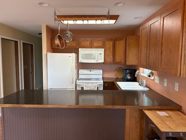 32813 Whispering Springs Loop, Erhard, MN 56534 - kitchen featuring white appliances, a peninsula, brown cabinets, and dark countertops