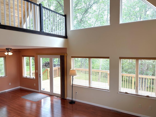 32813 Whispering Springs Loop, Erhard, MN 56534 - unfurnished living room featuring a towering ceiling, wood finished floors, and a ceiling fan