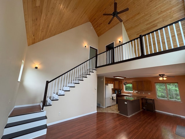 32813 Whispering Springs Loop, Erhard, MN 56534 - unfurnished living room featuring high vaulted ceiling, ceiling fan, stairway, dark wood-type flooring, and wood ceiling