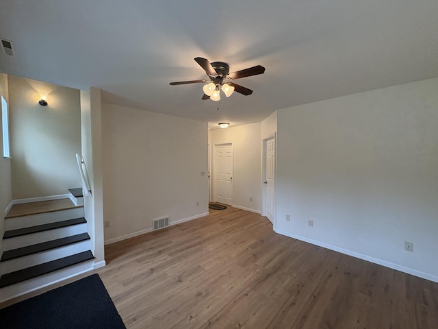 32813 Whispering Springs Loop, Erhard, MN 56534 - empty room featuring ceiling fan, light wood finished floors, and stairs