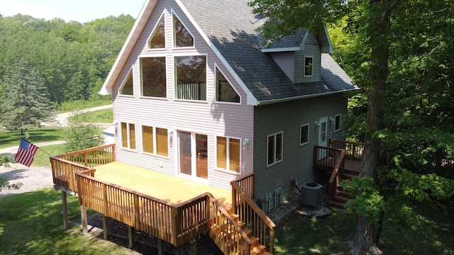 32813 Whispering Springs Loop, Erhard, MN 56534 - rear view of house featuring roof with shingles, a wooden deck, a wooded view, and a lawn