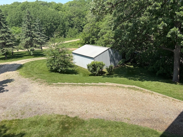 32813 Whispering Springs Loop, Erhard, MN 56534 - exterior space featuring a pole building, a lawn, an outdoor structure, and a forest view