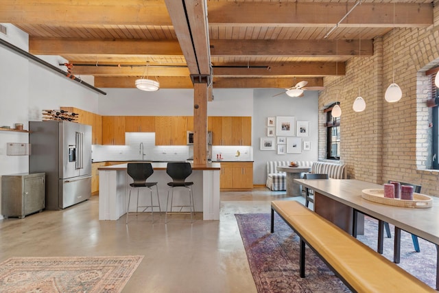 404 Washington Ave N Unit 401, Minneapolis, MN 55401 - kitchen with high quality fridge, brick wall, a sink, wood ceiling with exposed beams, and concrete floors